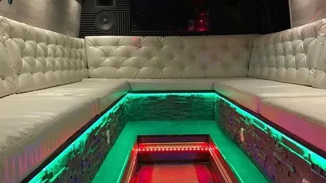 L-formet lounge med lys grå polstring og fargerik LED-belysning under setene