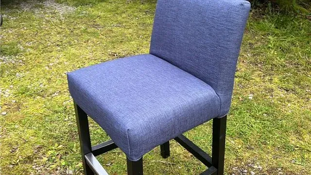 Blå spisestol med enkel rygg og svarte treben, plassert på gress